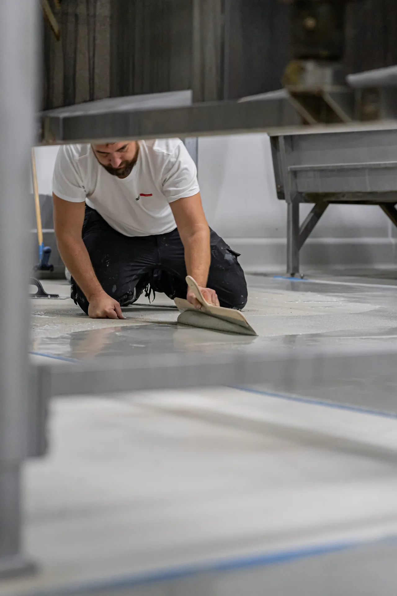 SQM szakember műgyanta padlót simít egy gyártóüzemben